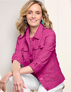 seated woman wearing mauve eyelet jacket and white pants