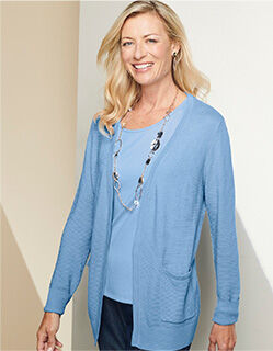 smiling model wearing light blue cardigan with matching shirt underneath