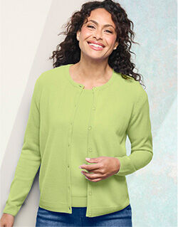 smiling model wearing pale green cardigan with matching tank underneath, blue jeans