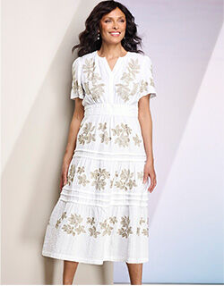 model wearing embroidered dress in white with beige highlights