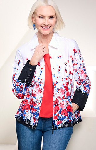 model wearing white jean jacket with red and blue floral pattern, and blue jean