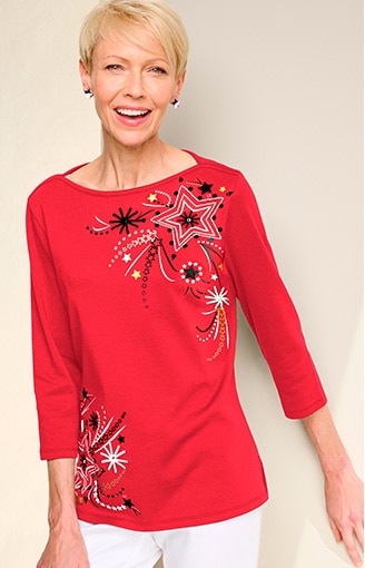 model wearing red 3/4 sleeve knit top with red, white, and blue design, white pants