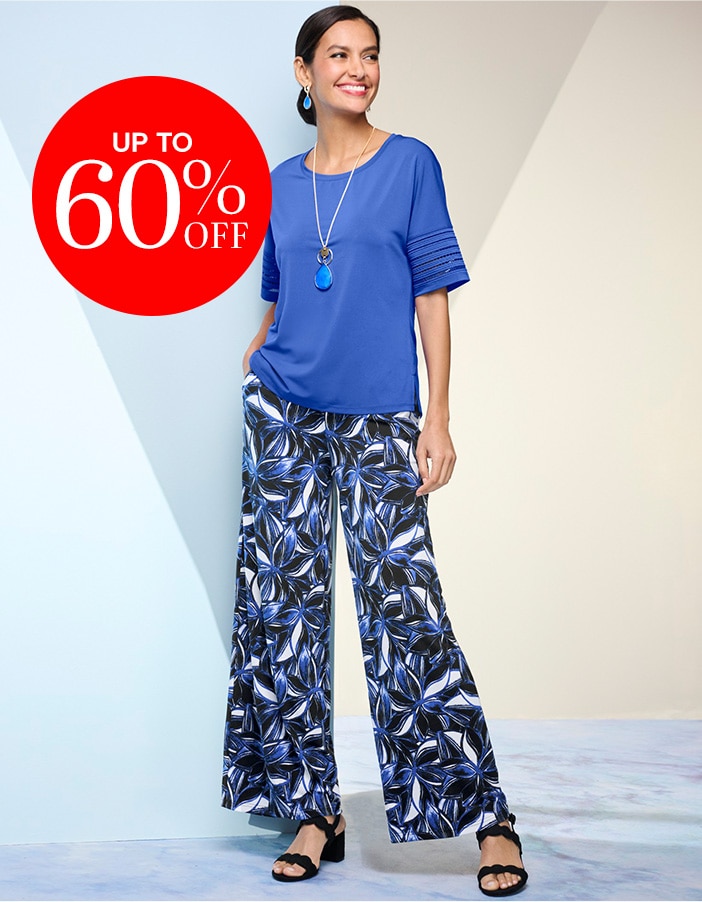 model wearing medium blue short-sleeve blouse with blue, black, and white floral pants